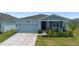 Charming home with well-manicured lawn, landscaping, and a two-car garage at 34568 Shellback St, Leesburg, FL 34788