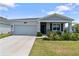 Charming single-story home featuring a well-manicured lawn, attached garage, and welcoming front porch at 34568 Shellback St, Leesburg, FL 34788