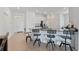 Kitchen with bar seating, stainless steel appliances, and modern white cabinetry at 34568 Shellback St, Leesburg, FL 34788