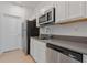 Kitchen featuring stainless steel appliances, gray countertops, and white cabinets at 34568 Shellback St, Leesburg, FL 34788