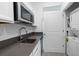 A kitchenette features stainless steel appliances, gray countertops, and white cabinets at 34568 Shellback St, Leesburg, FL 34788