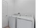 Practical laundry room with a modern washer and dryer, adjacent to a white door at 34568 Shellback St, Leesburg, FL 34788