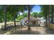 Serene backyard with mature trees, wrought iron fencing, and covered patio perfect for outdoor relaxation and entertaining at 357 Heritage Estates Ln, Deland, FL 32720