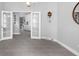 View of the dining room leading to the kitchen, highlighted by gray flooring, and white french doors at 357 Heritage Estates Ln, Deland, FL 32720