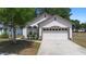 Charming front view of a well-maintained home with a two-car garage and professionally landscaped front yard at 357 Heritage Estates Ln, Deland, FL 32720