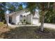 Landscaped yard featuring well-maintained lawn, lush trees, and a charming home exterior at 357 Heritage Estates Ln, Deland, FL 32720