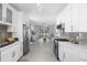 View of the modern kitchen with stainless steel appliances, and white cabinetry, leading into the living space at 357 Heritage Estates Ln, Deland, FL 32720