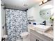 Well-lit bathroom with a vessel sink, a large mirror, and a shower with a patterned curtain at 3800 Saxon Dr # 150, New Smyrna Beach, FL 32169