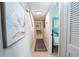 Hallway features natural lighting and coastal-themed art, leading to bedrooms and main living areas at 3800 Saxon Dr # 150, New Smyrna Beach, FL 32169