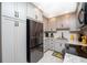 Close-up of the remodeled kitchen featuring grey cabinets, granite counters, and black appliances at 3800 Saxon Dr # 150, New Smyrna Beach, FL 32169