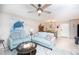 Cozy living room with blue furniture, a turtle art piece and dining area in background at 3800 Saxon Dr # 150, New Smyrna Beach, FL 32169