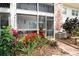 Relax on this private patio surrounded by lush landscaping with red flowers and tropical plants at 3800 Saxon Dr # 150, New Smyrna Beach, FL 32169