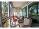 Enjoy the outdoors with this screened porch featuring three chairs with throw pillows and a sunflower picture at 3800 Saxon Dr # 150, New Smyrna Beach, FL 32169