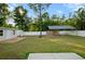 Fenced backyard featuring a storage shed, covered patio, and lush green grass at 430 Spring Dr, Ocala, FL 34472