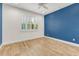 Comfortable bedroom featuring natural light, stylish flooring, and a serene blue accent wall at 484 Landshark Blvd, Daytona Beach, FL 32124