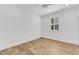 Bright bedroom features wood-look flooring, a ceiling fan, and a window with white shutters at 484 Landshark Blvd, Daytona Beach, FL 32124