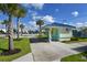 Charming exterior view of a pool house with teal trim, palm trees, and ample parking at 484 Landshark Blvd, Daytona Beach, FL 32124