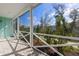 This screened-in porch features a paved stone floor and white railing, perfect for enjoying the view at 484 Landshark Blvd, Daytona Beach, FL 32124