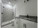 Modern bathroom featuring granite counters, white cabinets and glass enclosed shower at 516 Model St, Daytona Beach, FL 32114