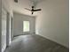 Bright bedroom with gray floors, a modern ceiling fan, and a large window providing natural light at 516 Model St, Daytona Beach, FL 32114