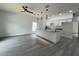 Open-concept living and kitchen with gray wood-look floors and granite counter tops at 516 Model St, Daytona Beach, FL 32114