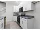 Bright kitchen featuring granite counters, and white cabinetry at 561 Coronado Cove Road, New Smyrna Beach, FL 32168