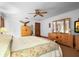 Bright bedroom with a ceiling fan, wood furnishings, and a floral-patterned bedspread at 585 Summerhaven Dr, Debary, FL 32713