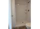Walk-in shower with white tile, shower head and shelves at 600 N Boundary Ave # 114-C, Deland, FL 32720