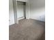 Bedroom boasts neutral carpet and a closet with louvered doors for organized storage at 600 N Boundary Ave # 114-C, Deland, FL 32720