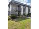 Exterior of a well-maintained two-story condo with charming landscaping, plants and a lawn at 600 N Boundary Ave # 114-C, Deland, FL 32720