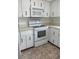 Classic condo kitchen featuring white cabinets, appliances, and tile floors at 600 N Boundary Ave # 114-C, Deland, FL 32720