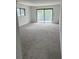 Spacious condo living room with neutral walls, carpet, and large sliding door to a balcony at 600 N Boundary Ave # 114-C, Deland, FL 32720