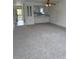Open-concept living space with neutral carpet flows into an adjacent kitchen with breakfast bar seating at 600 N Boundary Ave # 114-C, Deland, FL 32720