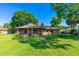 Spacious backyard with lush green grass, mature trees, and screened-in porch at 61 Bryan Cave Rd, South Daytona, FL 32119
