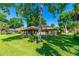Spacious backyard with lush green grass, mature trees, and screened-in porch at 61 Bryan Cave Rd, South Daytona, FL 32119