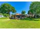 Spacious backyard with lush green grass, mature trees, and screened-in porch at 61 Bryan Cave Rd, South Daytona, FL 32119