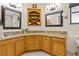 Bathroom with dual sinks, granite countertops, wood cabinets and decorative wall shelves at 61 Bryan Cave Rd, South Daytona, FL 32119