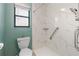 Bright bathroom featuring a window, toilet and marble-walled accessible shower at 61 Bryan Cave Rd, South Daytona, FL 32119
