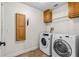 Functional laundry room with washer, dryer, built-in cabinets, and tile flooring at 61 Bryan Cave Rd, South Daytona, FL 32119