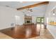 Spacious living room with wood beam, brick fireplace, and hardwood floors showcases an inviting design at 61 Bryan Cave Rd, South Daytona, FL 32119