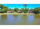 Rear exterior view of a home on a lake with lush landscaping at 61 Bryan Cave Rd, South Daytona, FL 32119