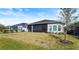 A backyard view of the screened in patio and well manicured yard at 617 Mosaic Blvd, Daytona Beach, FL 32124