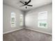 Bright bedroom with gray walls, gray carpet, ceiling fan, and lots of natural light from the three windows at 617 Mosaic Blvd, Daytona Beach, FL 32124