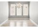 Bright dining room featuring neutral walls, tiled floor, and an elegant chandelier between three large windows at 617 Mosaic Blvd, Daytona Beach, FL 32124