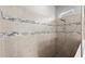 Elegant tiled shower featuring decorative inlays, a rain shower head, and built in shower caddy at 617 Mosaic Blvd, Daytona Beach, FL 32124
