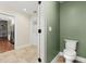 Bathroom with a toilet, tile floor, and view to the kitchen with hardwood flooring at 6185 Shoreline Dr, Port Orange, FL 32127