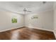 Empty bedroom featuring hardwood floors, neutral walls, and two windows at 6185 Shoreline Dr, Port Orange, FL 32127