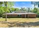 Charming single-story brick home featuring a well-kept lawn, unique clerestory windows, and a modern front door at 6185 Shoreline Dr, Port Orange, FL 32127
