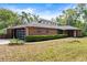 Eye-catching brick home with a modern garage door, well-manicured landscaping, and unique architectural details at 6185 Shoreline Dr, Port Orange, FL 32127