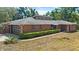 Charming brick home with a modern garage door, well-maintained landscaping, and a contemporary roof design at 6185 Shoreline Dr, Port Orange, FL 32127